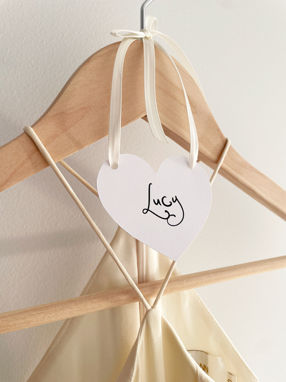 Bridesmaid hanger with a heart name tag labeled 'Lucy'